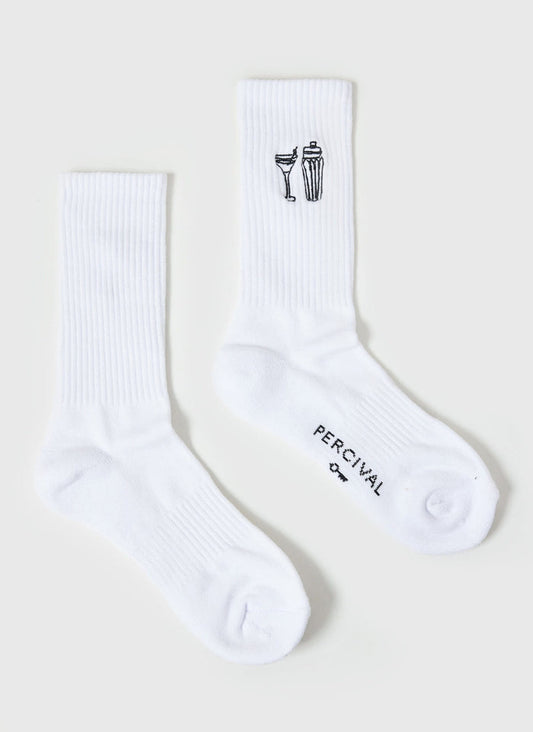 The Percival Mixologist Embroidered Socks in white, laid flat to showcase the cocktail glass and shaker embroidery.