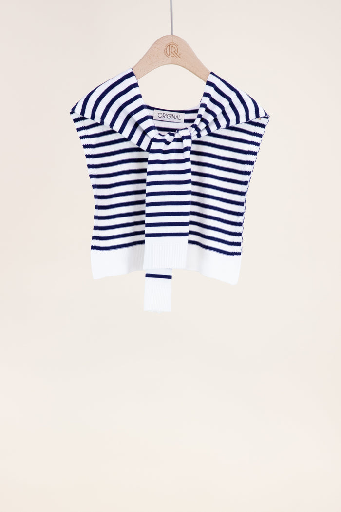 Blue and white striped sweater on a hanger against a beige background