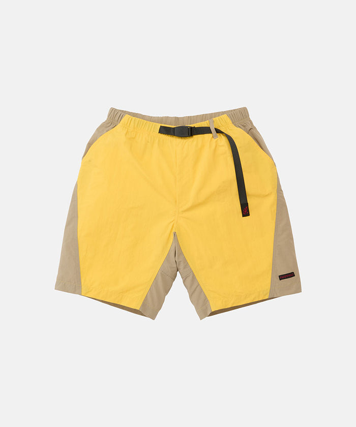 Banana colored Gramicci Nylon Block Shorts with a belt against a light-tone background.