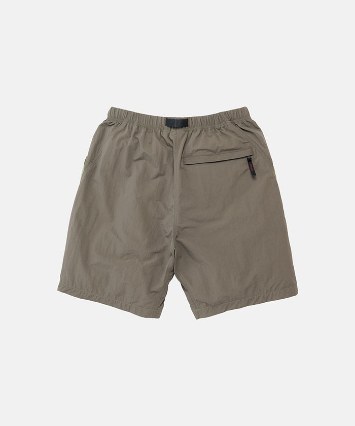 Back view of jade green Gramicci Nylon Block Shorts on a light-tone background.