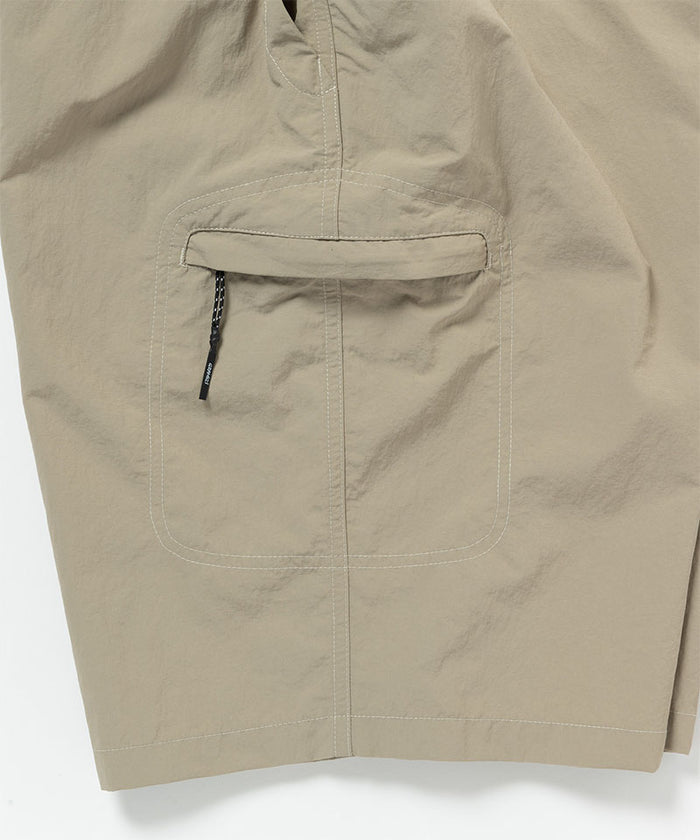Close-up view of milk tea colored Gramicci Nylon Cliff Short pocket detail on a light-tone background.