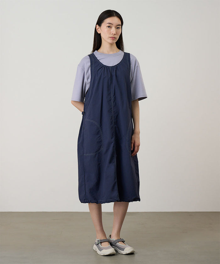 Model wearing a british navy colored Gramicci Nylon Dress and a lavender shirt on a light-tone background.