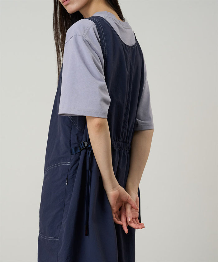 Model wearing a british navy colored Gramicci Nylon Dress and a lavender shirt on a light-tone background.