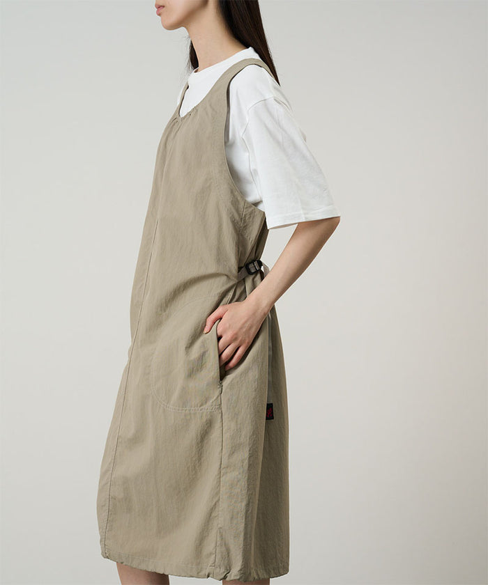 Model wearing a milk tea colored Gramicci Nylon Dress and a white shirt on a light-tone background.