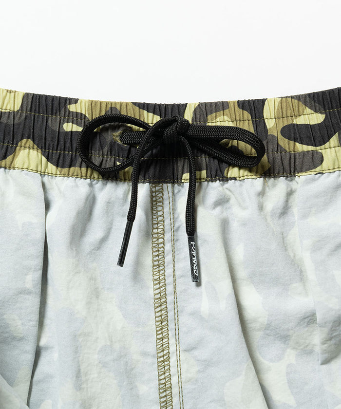 Inside view of the olive camo Gramicci Nylon Reef Shorts with drawstring against a light-tone background.