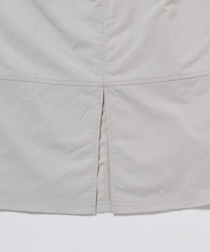 Gramicci ecru colored Nylon Utility Skirt hem detail against a light-tone background.
