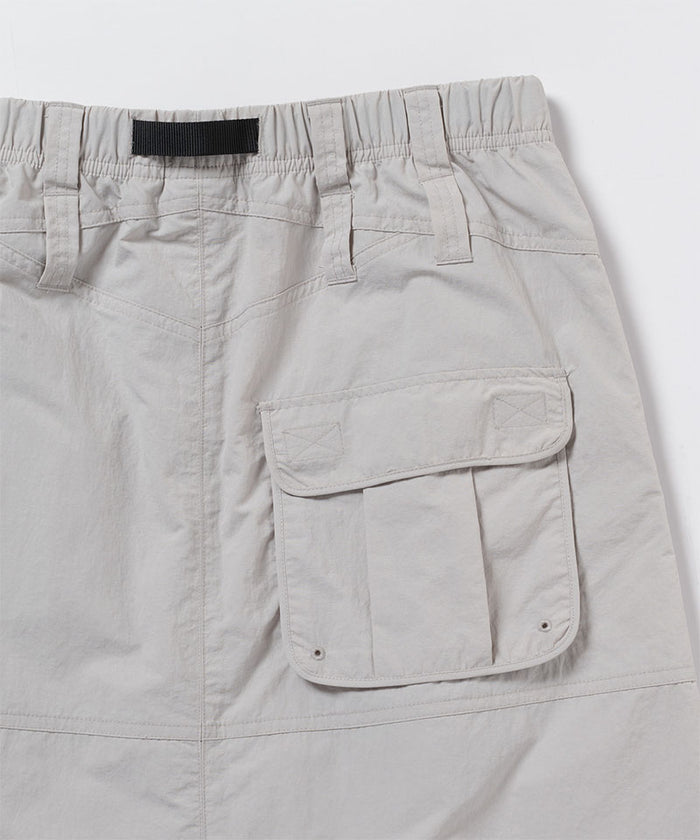 Close-up view of an ecru colored Gramicci Nylon Utility Skirt back pocket on a light-tone background.