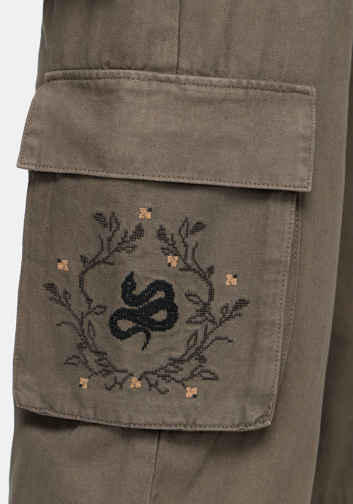 Snake embroidered design on a pocket of brown wide leg cargo pants