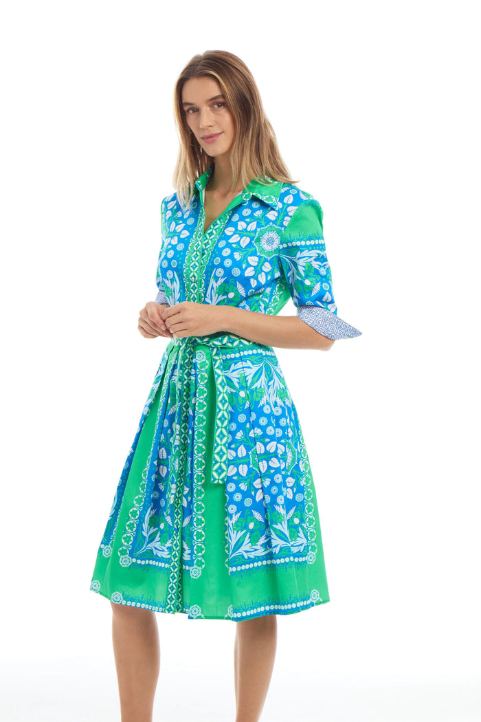 Woman wearing a green and blue patterned dress on a white background