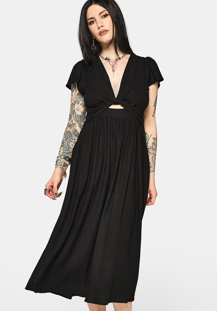 Woman wearing a black dress with cut-out design and short sleeves on a white background
