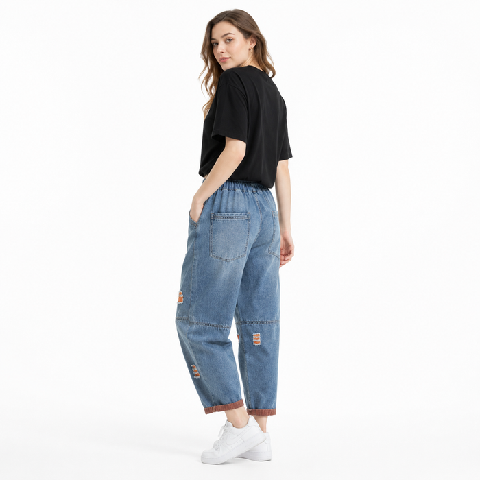 Relaxed women's denim pants with distressed detail, structured seams, and practical design for daily wardrobe use.
