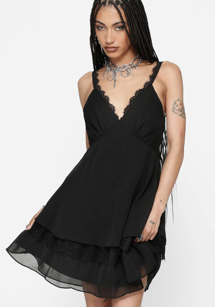 Black lace mini dress worn by a model on a white background