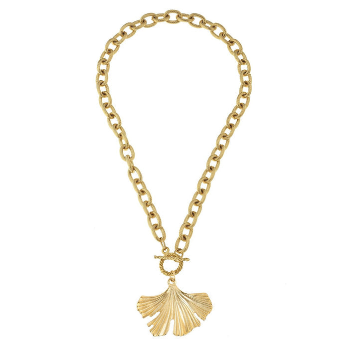 Gold chain necklace with a ginkgo leaf pendant on a white background