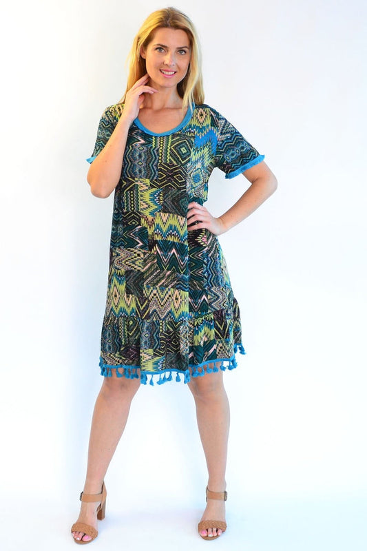 Zen Garden Tasseled Cha Cha Crinkle Tunic Dress displayed on a hanger, showcasing its flowy fabric and tassel details.