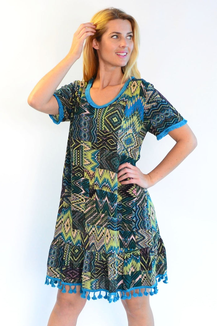 Zen Garden Tasseled Cha Cha Crinkle Tunic Dress hanging on a hanger, showing its relaxed fit and crinkled fabric detail.