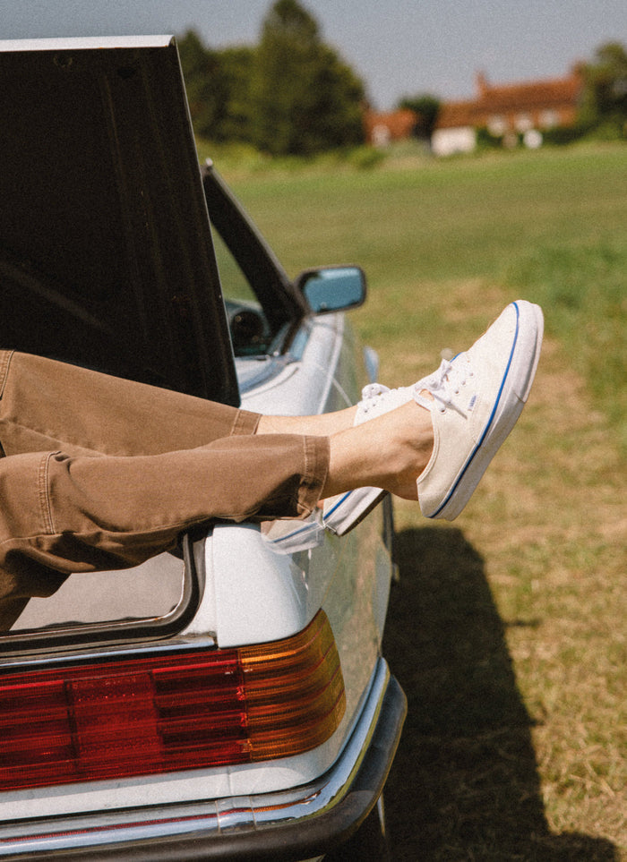 Off white Vans Premium Authentic 44 canvas trainers from Percival, worn with brown trousers in a vintage car boot.