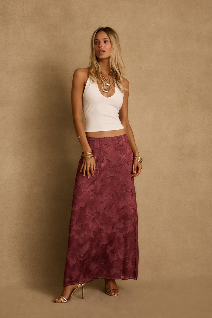 Mulberry floral-textured maxi skirt styled with a white halter tank and gold heels.