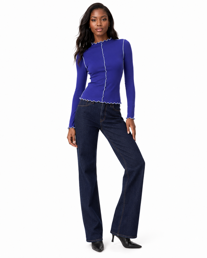 Close view of the mock neckline with wavy lettuce trim on a women's stretchy long sleeve top with visible contrast stitching.