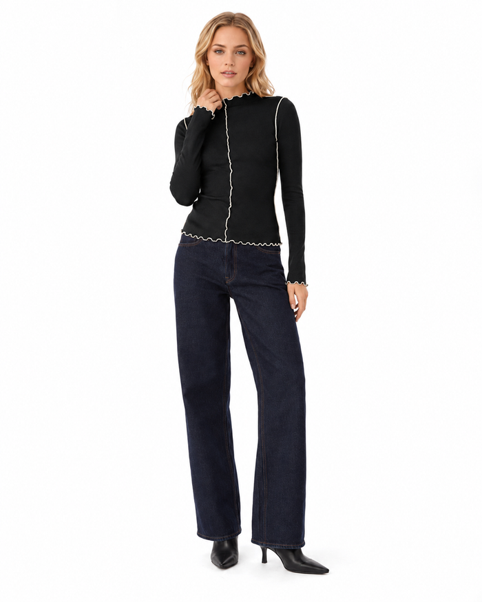 Detail view of contrast stitching and wavy lettuce trim on a women's mock neck long sleeve top for everyday wear and styling.
