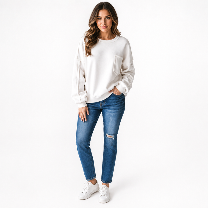 Women's white top with pockets and subtle exposed seam detail, smooth polyester fabric and modern relaxed fit for daily wear.