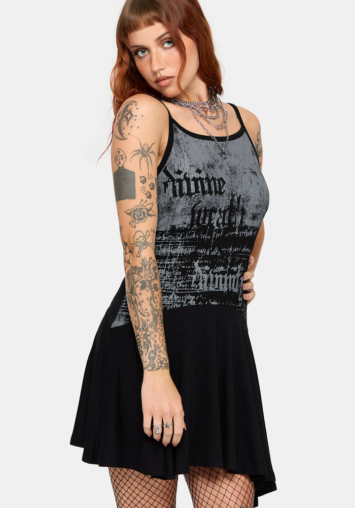 A woman modeling a sleeveless black and gray graphic mini dress, shown against a plain light gray studio background.